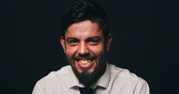 Portrait, psychology or man in studio with bipolar, dark or isolated background for mental health. Laugh, manic or person in distress with smile, dismissal or fired in corporate for missed deadline.