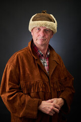 Portrait of a serene aged cowboy trapper in studio