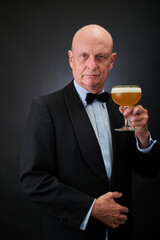 Portrait of a serene aged and balded man with bow tie and tuxedo suit