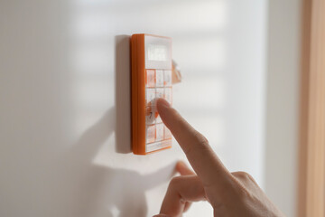 A woman uses a kitchen timer attached to the refrigerator.　冷蔵庫に取り付けられたキッチンタイマーを使う女性