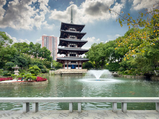 Tranquil Pagoda Reflected in Serene Waters Under Dramatic Skies
