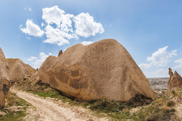 a geologically formed dirth hill near a path under blue sky