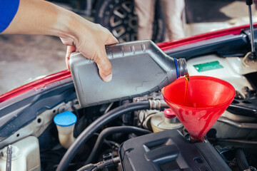 technician changing engine oil and performing vehicle service in a garage, professional auto mechanic work, tools and car parts, clean and organized workshop