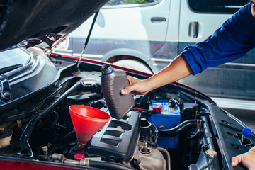 technician changing engine oil and performing vehicle service in a garage, professional auto mechanic work, tools and car parts, clean and organized workshop