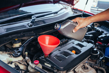 technician changing engine oil and performing vehicle service in a garage, professional auto mechanic work, tools and car parts, clean and organized workshop