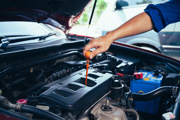 technician changing engine oil and performing vehicle service in a garage, professional auto mechanic work, tools and car parts, clean and organized workshop