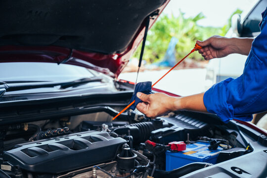 technician changing engine oil and performing vehicle service in a garage, professional auto mechanic work, tools and car parts, clean and organized workshop