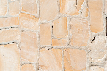 Antique ancient stone wall masonry texture background. Old wall made of beige stone blocks 
