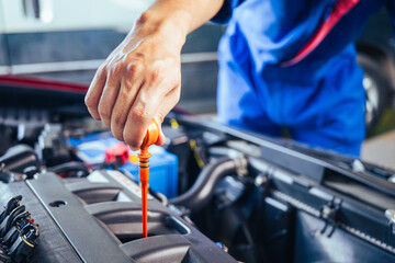 technician changing engine oil and performing vehicle service in a garage, professional auto mechanic work, tools and car parts, clean and organized workshop