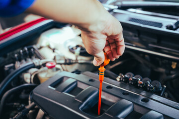 technician changing engine oil and performing vehicle service in a garage, professional auto mechanic work, tools and car parts, clean and organized workshop