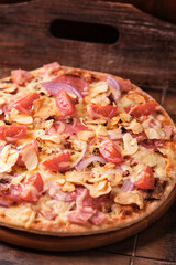 Pizza with chorizo ​​sausage, mozzarella cheese and yellow pepper. Rustic wooden background. Soft focus.	