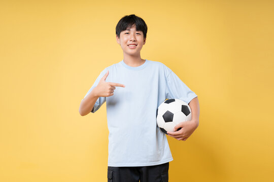 Enthusiastic young soccer player on yellow background Ready for the match? Check it out now!