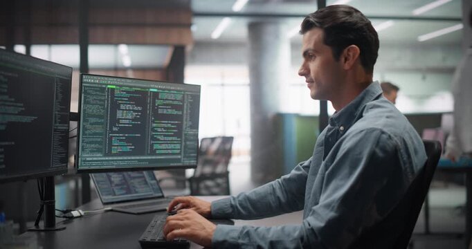 Handsome Multiethnic Male Working in Computer Terminal with Software Source Code. Programmer Working Surrounded by Big Screens with Data, Analytics and Running IT Management Tasks