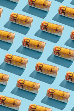 Fifty euro notes rolled in seamless pattern on blue background with copy space