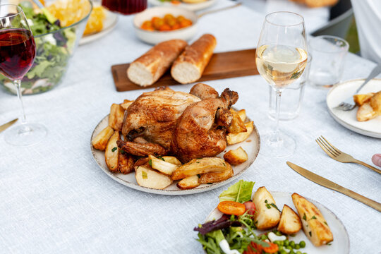 Delicious roasted turkey and potatoes sharing focus with wine glasses on festive table setting