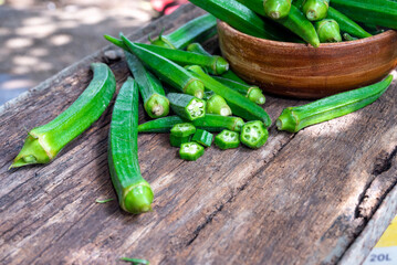 Lady Fingers or Okra over wooden table background. Raw Green Organic Okra Harvest Ready to Cook With. Close up Farm fresh okro on wooden rustic table.