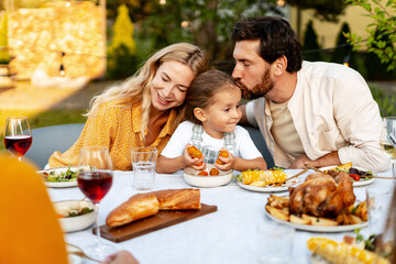 Happy family enjoying garden party with roasted turkey and wine, thanksgiving day