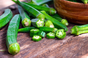 Lady Fingers or Okra over wooden table background. Raw Green Organic Okra Harvest Ready to Cook With. Close up Farm fresh okro on wooden rustic table.