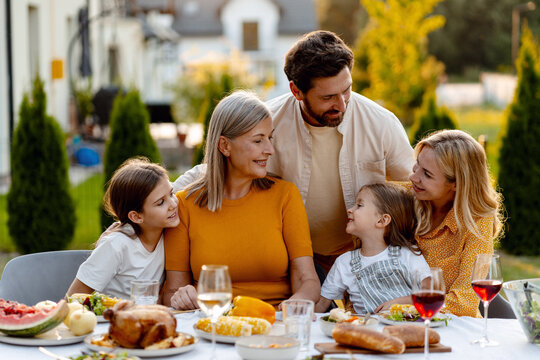 Happy family enjoying garden party with roasted turkey and wine, holiday, celebration
