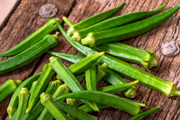 Lady Fingers or Okra over wooden table background. Raw Green Organic Okra Harvest Ready to Cook With. Close up Farm fresh okro on wooden rustic table.