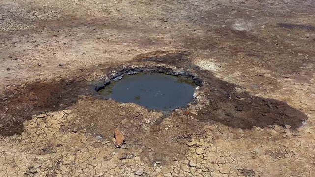 Top view of a mud volcano. A tourist destination in Gobustan, Azerbaijan. The volcano is surrounded by a desert landscape where no vegetation is visible.
