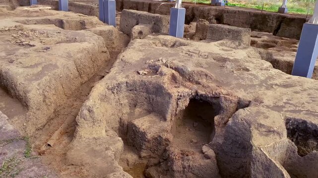 Research excavations of an ancient civilization near the ancient city in Gabala (Chukhur Gabala), Azerbaijan. A desolate sandy landscape with large holes in the ground.