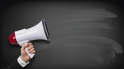 Hand holding megaphone shouting out news and announcement now