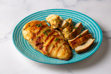 Grilled chicken breast slices served with mashed potatoes and vegetables.