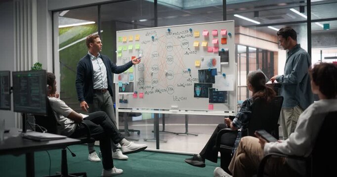 Computer Science Research Meeting with a Specialist Reporting to a Group of Engineers and Managers. Male Talks About Neural Networks, Machine Learning, Artificial Intelligence and Using a Whiteboard