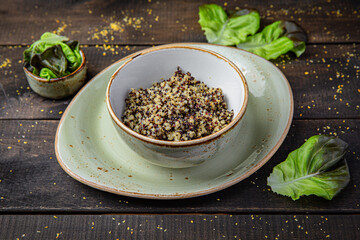 Quinoa porridge in a bowl on rustic brown wooden background. Healthy vegetarian breakfast.