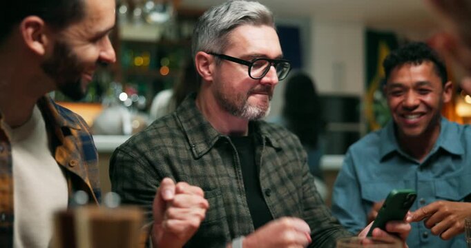 Winner, phone and fist pump with people at pub for streaming game, sports score and goal. Team support, fans celebration and competition with friends in bar for live broadcast and match results