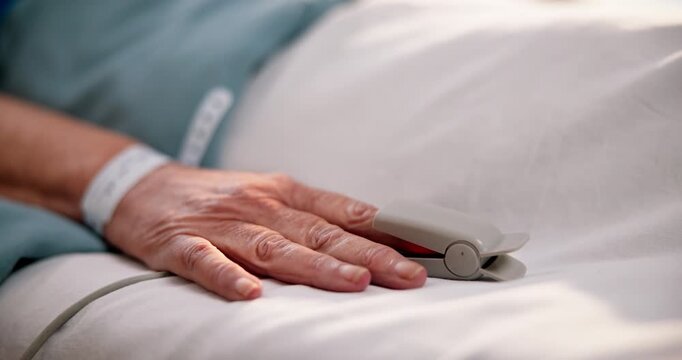 Oximeter, senior and patient hand in hospital for emergency care, track oxygen level and diagnosis. Elderly person, icu and monitor blood pressure for recovery, medical machine and healthcare