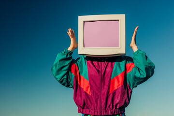 Vintage CRT monitor as head on person in 90s style track suit outdoors