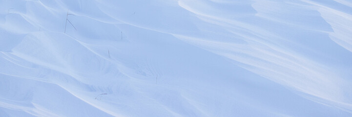 Snow texture. Wind sculpted patterns on snow surface. Wind in the tundra and in the mountains on the surface of the snow sculpts patterns and ridges. Arctic, Polar region. Winter panoramic background.