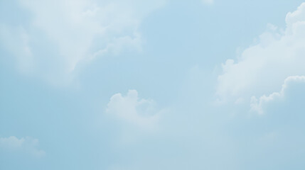 A light, pale blue sky dotted with gentle wisps of clouds, creating a tranquil and airy scene.