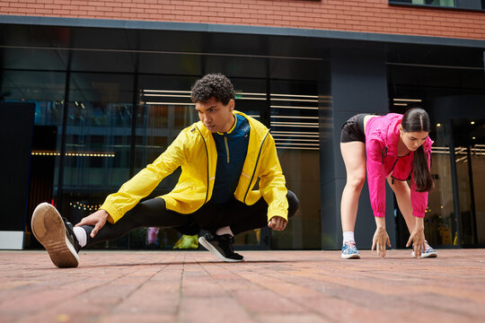 Young athletes preparing for training session on urban pavement with bright city backdrop