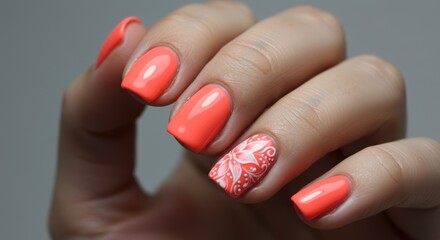 Close-up of bright coral manicure with floral accent nail design on short square nails