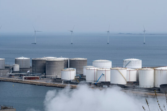 Copenhagen harbor industrial zone with Amager Bakke chimney and coastal skyline, reflecting transformation of city infrastructure toward clean energy and environmental design