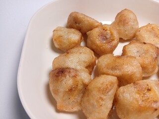 fried bananas or pisang goreng in white bowl. traditional indonesian snack. Isolated on white background
