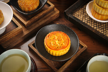 Traditional Chinese Mooncakes with Tea for Mid-Autumn Festival Celebration on Wooden Table