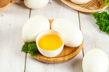 Fresh Goose Eggs on Wooden Tray Display with Golden Yolk and Parsley Garnish
