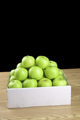Fresh Green Apples from Shaanxi Province China in Cardboard Box on Wood Table