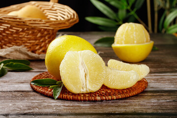 Fresh Pomelo Citrus Fruit Segments on Rustic Wooden Table with Wicker Basket
