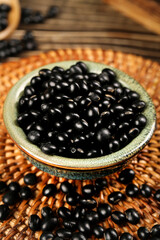 Black beans and mixed grains ingredients on rustic wooden background with wicker mat