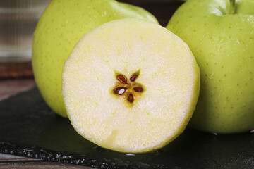 Fresh Xinjiang Green Apples Cut in Half Showing Seeds and Crisp White Flesh with Water Droplets