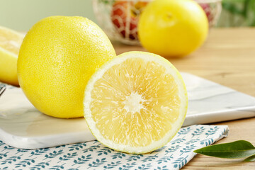 Fresh Yellow Pomelo Citrus Fruits on White Plate with Decorative Napkin