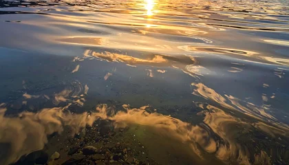 Wanddecoratie Reflectie A serene, golden sunset reflected beautifully on the water's surface, showcasing intricate patterns and colors.  © Xalek