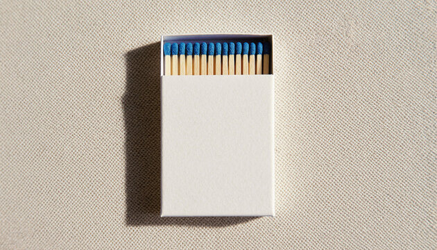 A blank white matchbox with blue tip matches. Top view flat lay on a textured background. Product packaging mockup with copy space for branding.