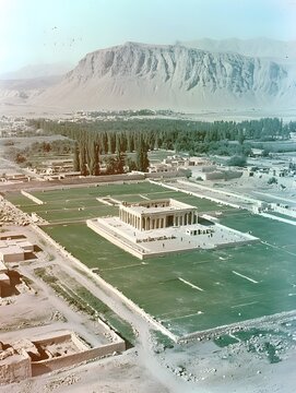 Historical aerial view of the Mausoleum of Mausolus against a mountain backdrop.