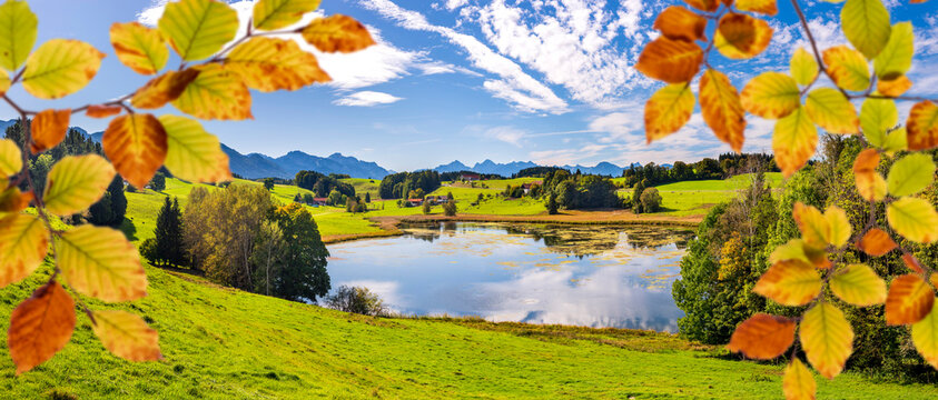 Sch&ouml;nes buntes Herbstlaub vor einem idyllischen See im Allg&auml;u bei Steingaden - FOTOMONTAGE